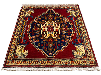Tapis rectangulaire à fond rouge, bleu foncé et bordures à motifs beiges