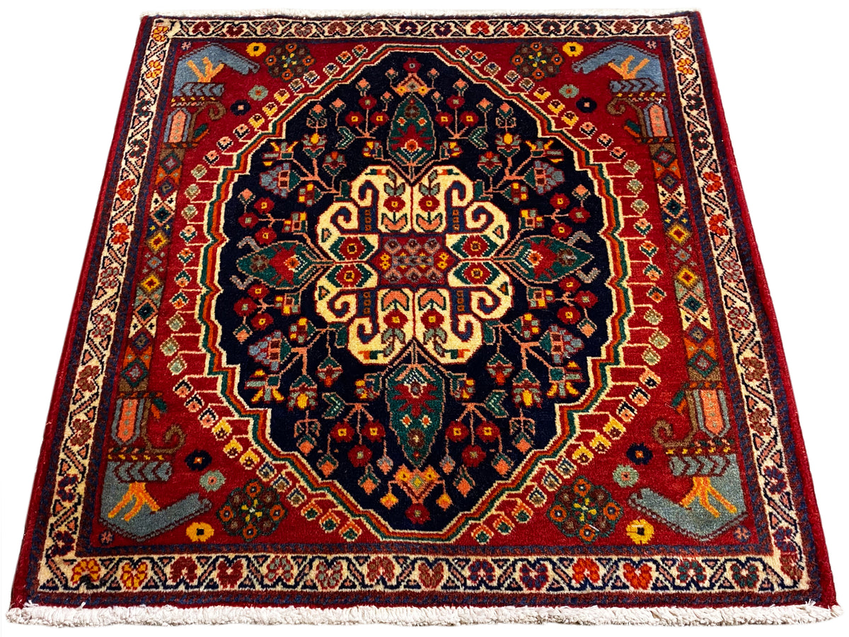 Tapis carré de 67x60 cm avec motif centré en bleu foncé, rouge et jaune