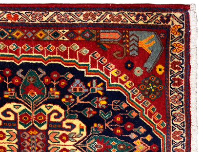 Détail du tapis : ornement coloré dans la zone bleu foncé sur fond rouge