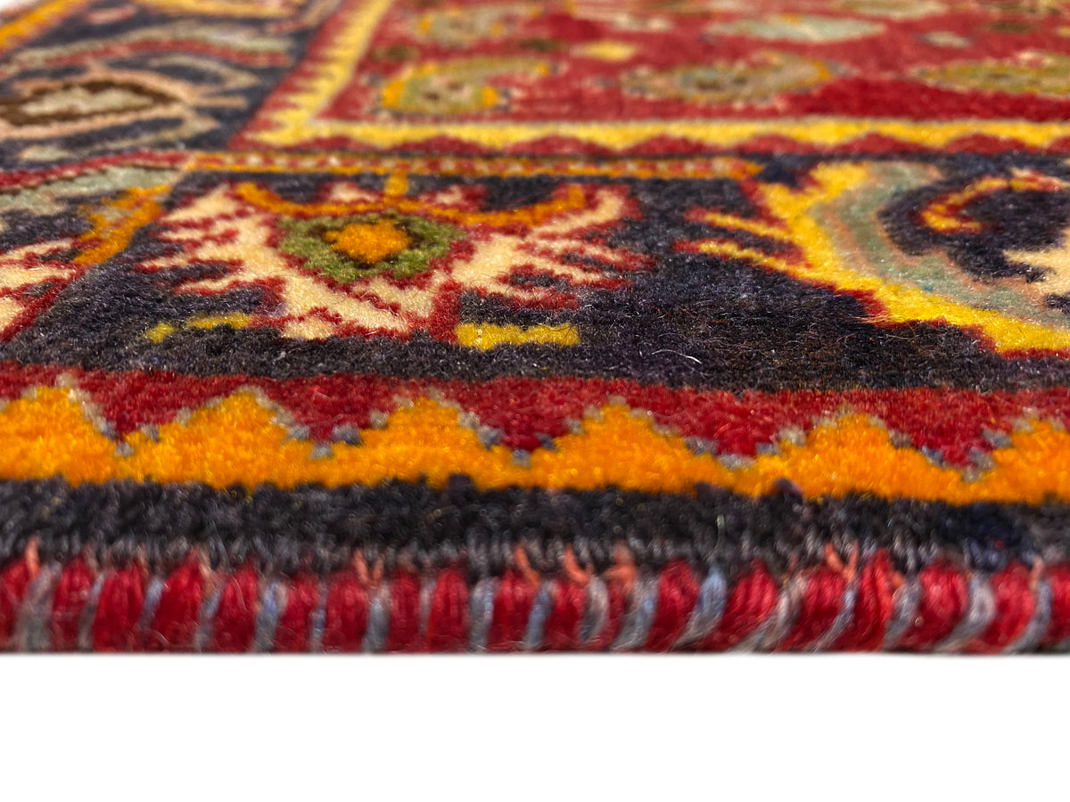Bord de tapis à franges et lisière à motifs en rouge, orange, bleu et noir