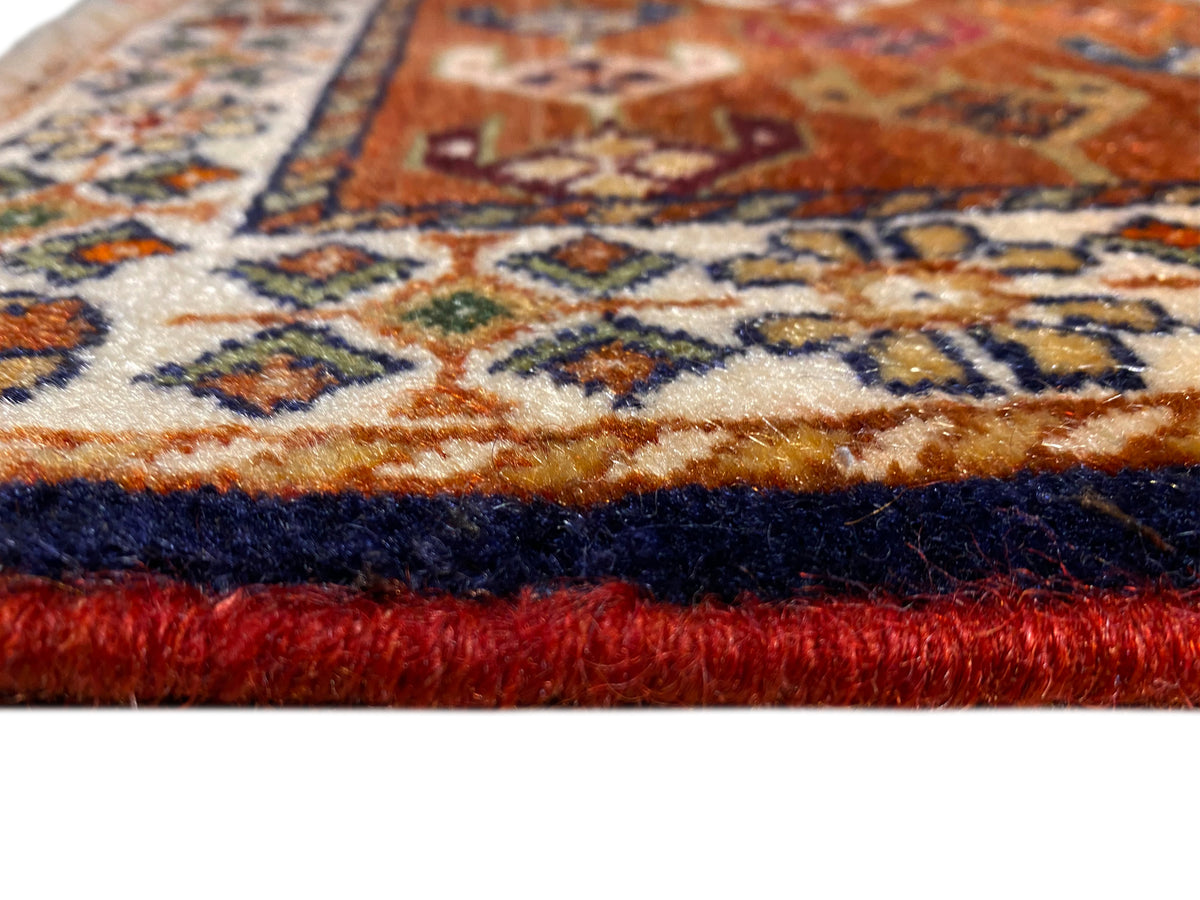 Gros plan du tapis Poshti 60x55 cm : franges et motif tissé multicolore sur le bord