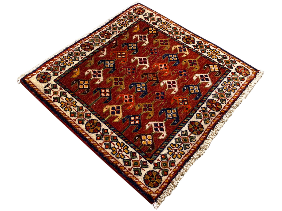 Tapis 61x61 cm à fond rouge avec des motifs géométriques colorés et une bordure tout autour