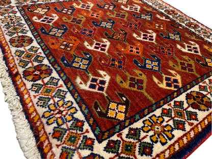 Tapis avec champ à motif rouge, bordure bleu turquoise et finition effilochée