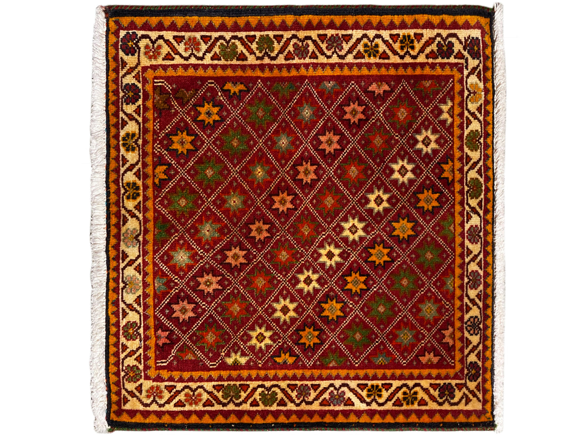 Tapis Poshti, rectangulaire, avec une décoration colorée ornée de motifs d’étoiles et de losanges dans le champ intérieur.