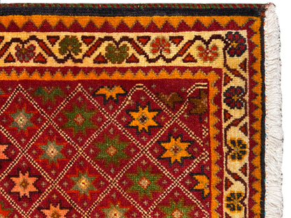 Vue détaillée du tapis Poshti : bordure ornée colorée et motif dense dans le champ intérieur.