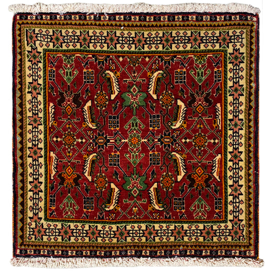 Tapis Poshti 63x61 cm avec motif rouge et vert, avec des franges sur le bord.