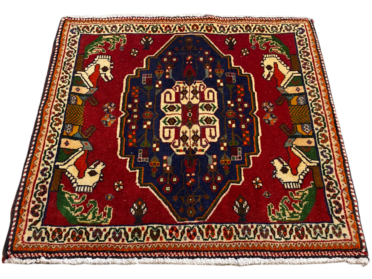 Tapis Poshti carré, fond rouge, médaillon central bleu et bordure multicolore