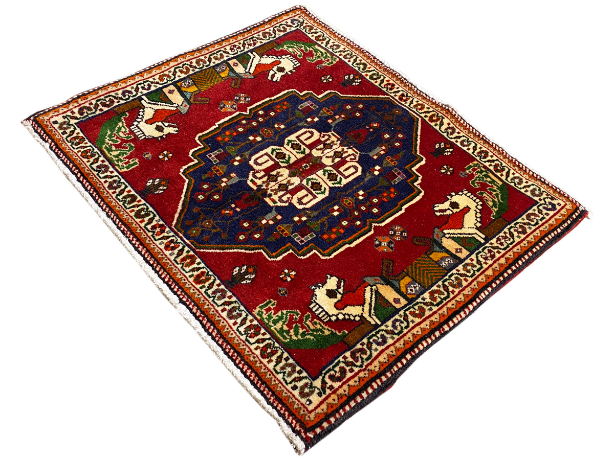 Tapis Poshti en forme de losanges, fond rouge, médaillon bleu et motifs animaliers