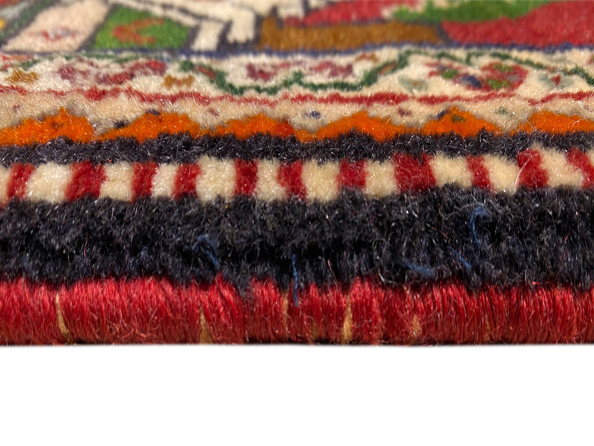 Détail du tapis Poshti : velours multicolore avec bordure de franges noires et rouges