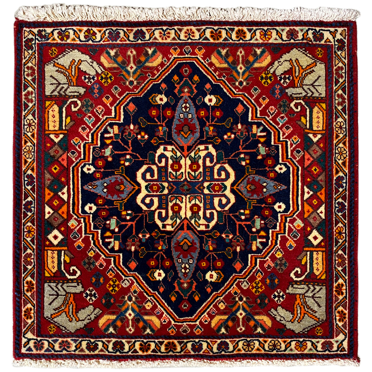 Tapis à bord rouge et motif de médaillon bleu, bordure tissée et franges