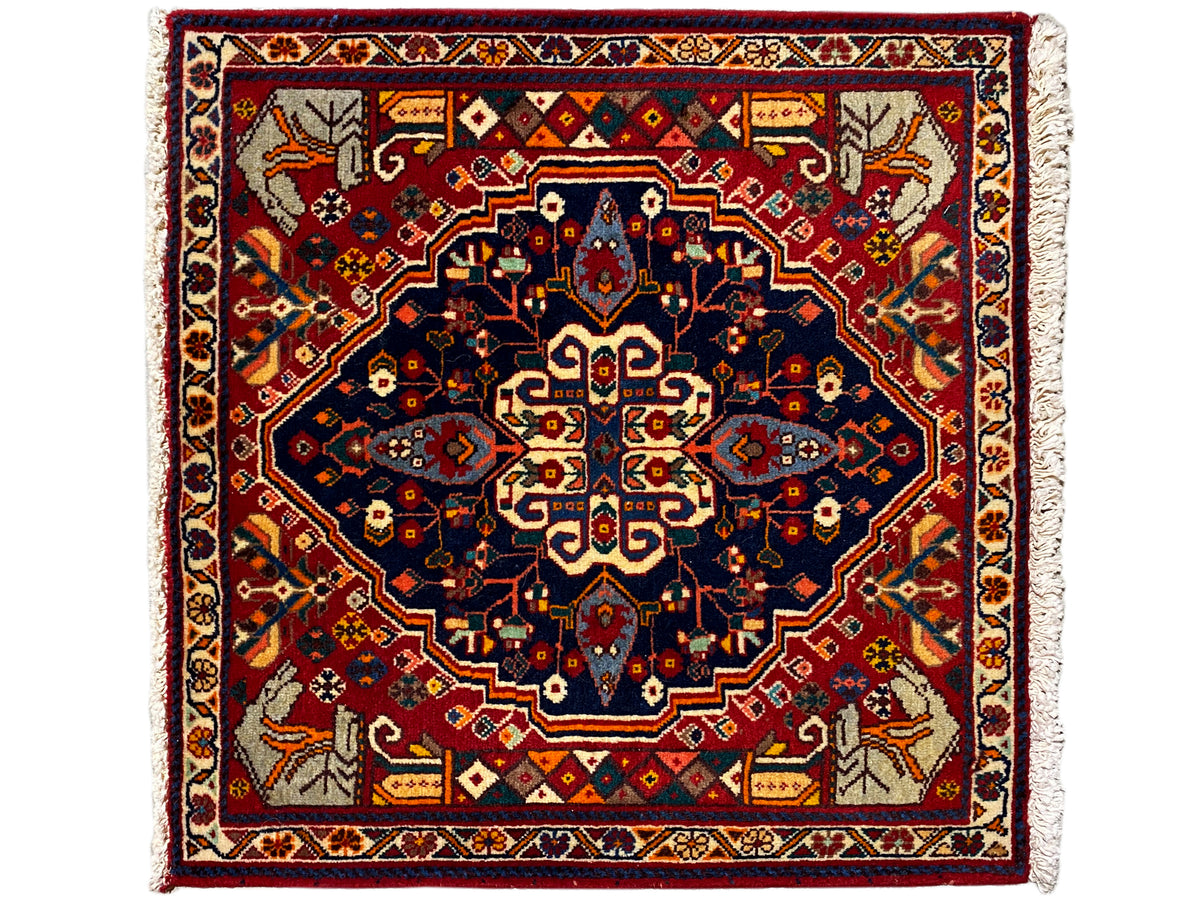 Tapis carré à fond rouge, étoile à motifs bleus et bordures décoratives
