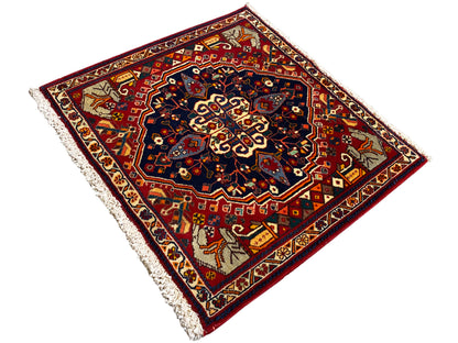 Tapis vu de dessus en biais : motif de bordure rouge, médaillon bleu et franges