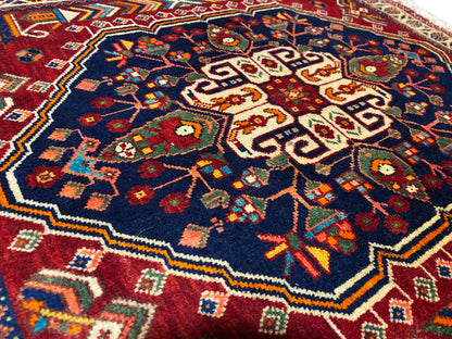 Tapis 63x60 cm en gros plan : motif floral coloré sur fond bleu foncé