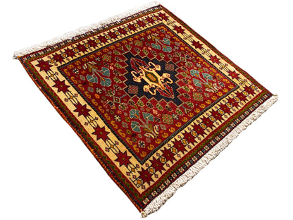 Tapis 60x58 cm, vue en diagonale : fond rouge, médaillon noir, franges aux coins