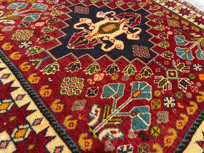 Détail du tapis : médaillon noir avec des motifs jaunes et des ornements colorés