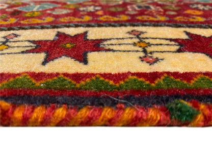 Bord du tapis en détail : étoiles rouges sur fond beige, ligne verte et franges