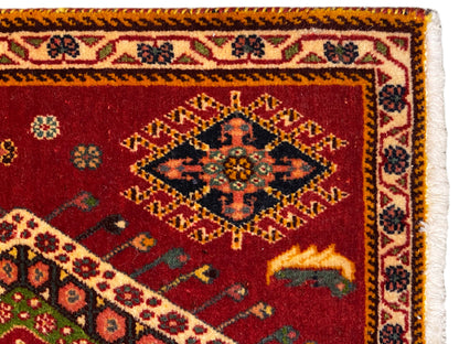 Gros plan d’un tapis Poshti : velours rouge avec bordure et franges