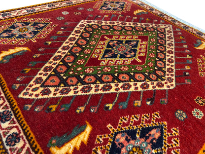 Détail du tapis Poshti : motif rouge avec médaillon coloré et bordure périphérique