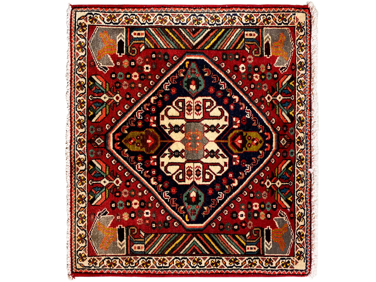 Tapis oriental à fond rouge, médaillon bleu foncé et ornements géométriques