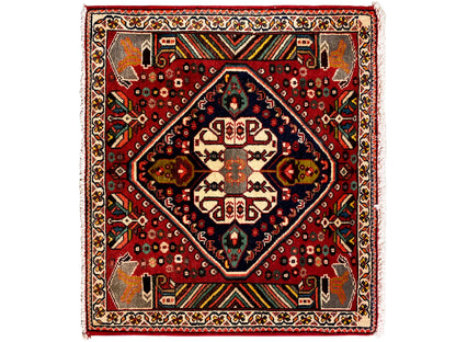 Tapis oriental à fond rouge, médaillon bleu foncé et ornements géométriques