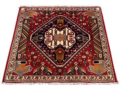Tapis oriental rectangulaire avec motif rouge, cadre intérieur bleu et ornements de bordure
