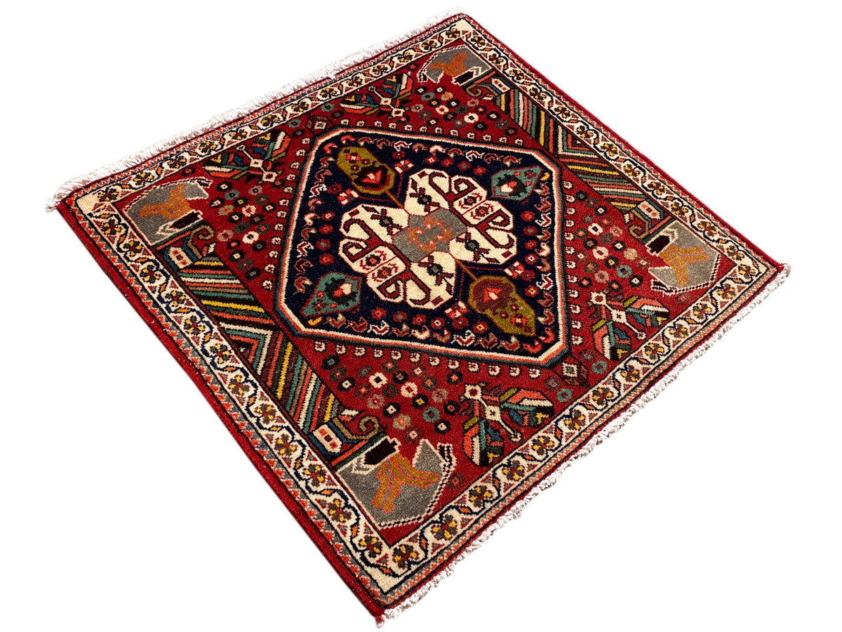 Tapis oriental carré à fond rouge et champ central bordé de bleu