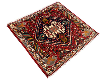 Tapis oriental carré à fond rouge et champ central bordé de bleu
