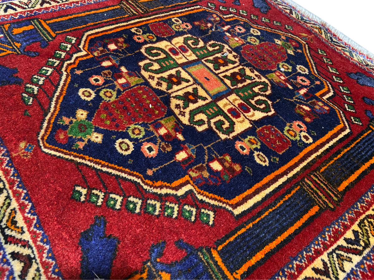 Tapis Poshti 66x62 cm Détail : motif central rouge, champ bleu et lignes décoratives colorées.