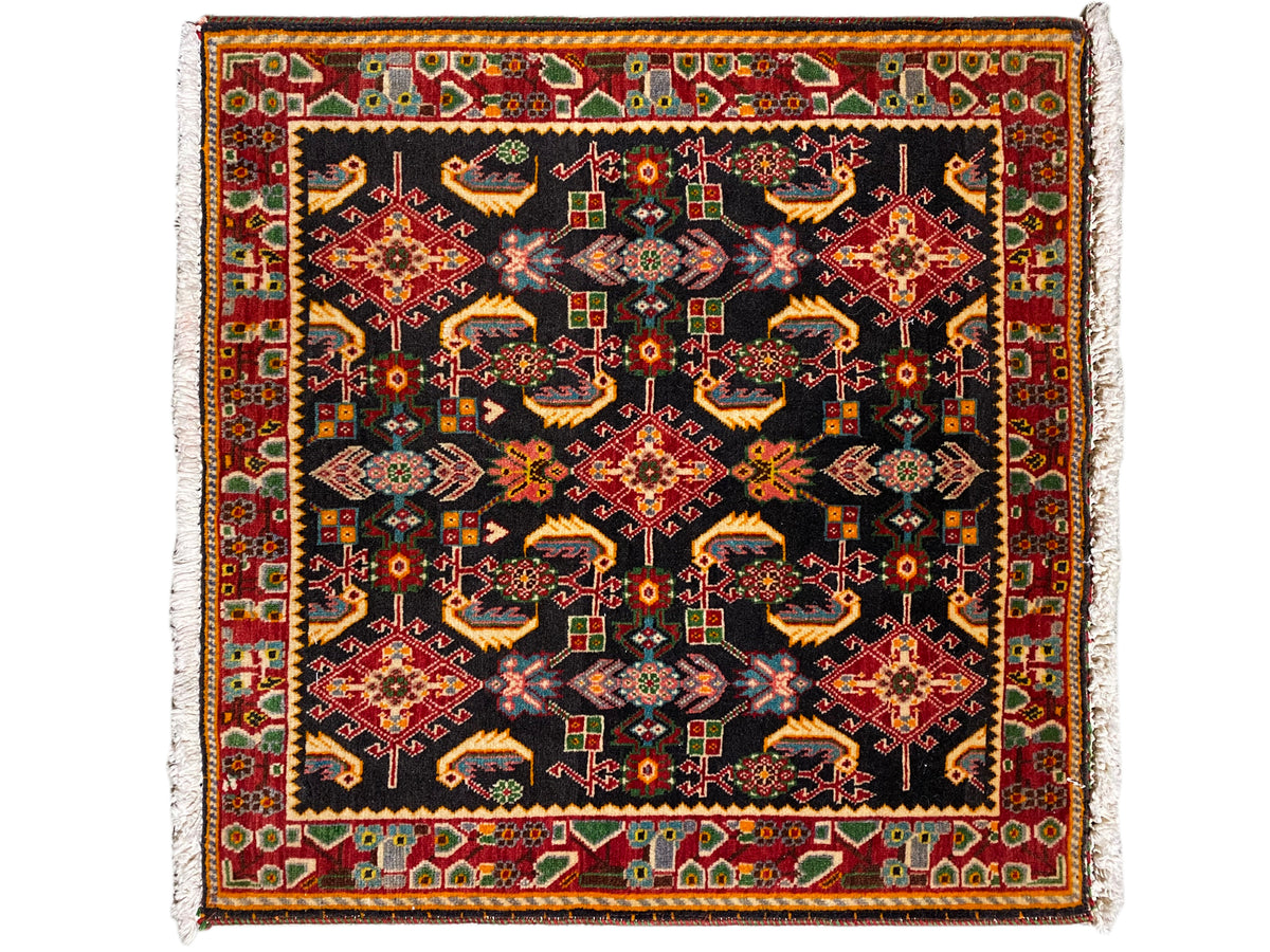 Tapis à motifs ornementaux carrés, noir comme couleur de base, tons rouges, jaunes et verts