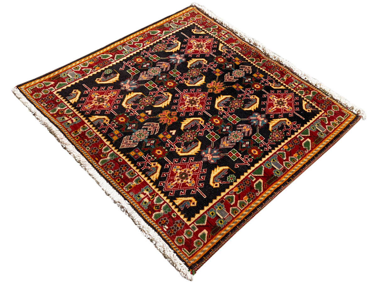 Tapis avec ornement central ornemental, noir, tons rouges et jaunes, accents verts