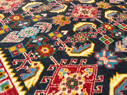 Surface de tapis ornée d’un motif géométrique coloré, noir, rouge, vert et jaune