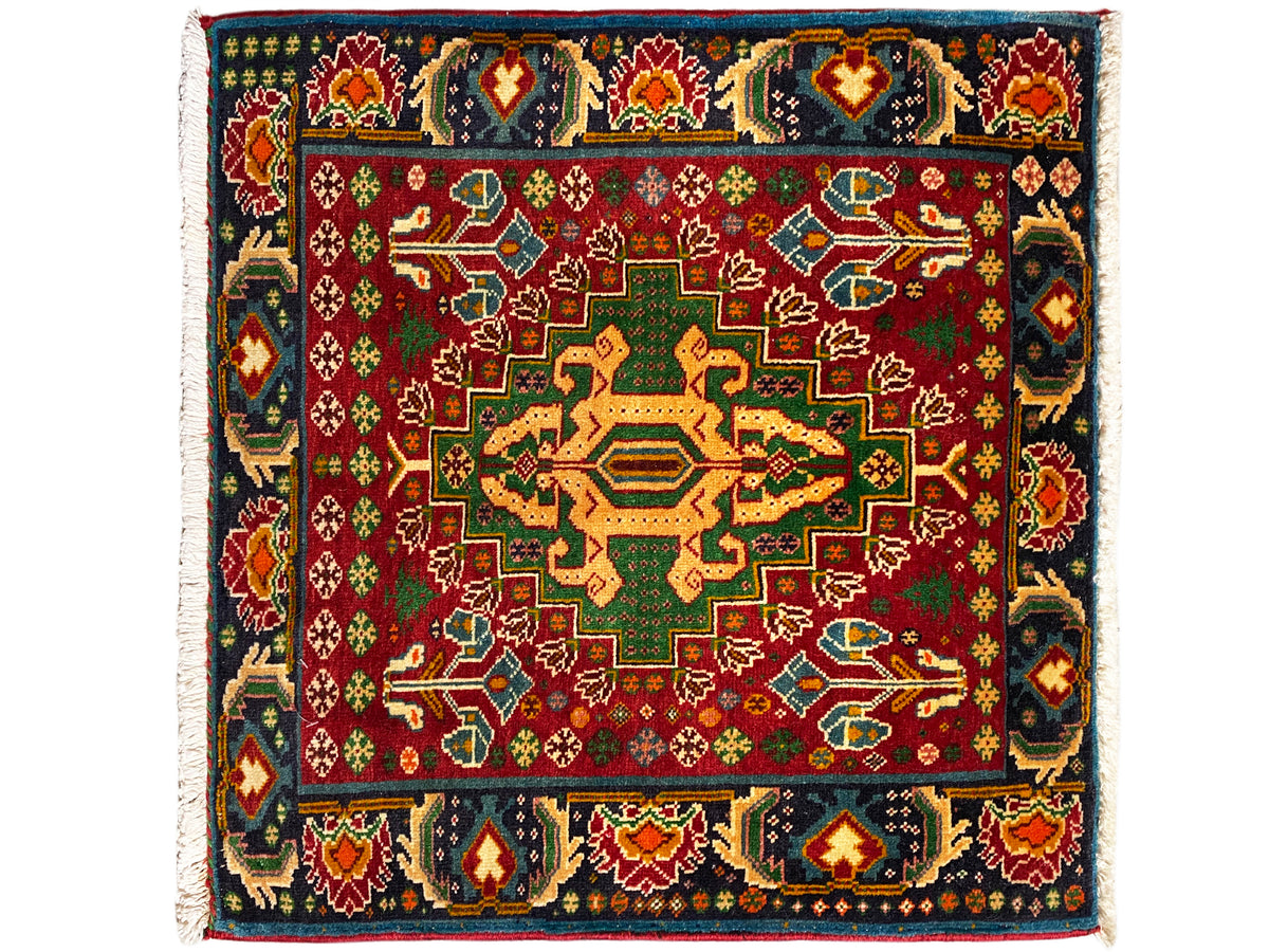 Tapis rectangulaire (67x66 cm) à fond rouge et bordure sombre, motif géométrique