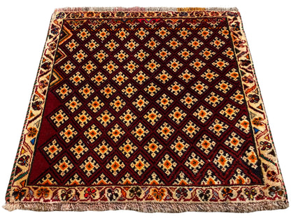 Tapis Poshti 61x59 cm : tapis rouge foncé à motif losanges et bordure périphérique à franges