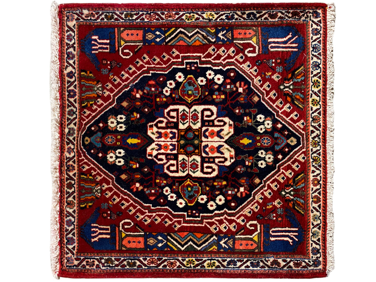 Tapis rectangulaire avec bordure rouge, champ intérieur bleu foncé et motif géométrique