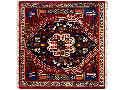 Tapis rectangulaire avec bordure rouge, champ intérieur bleu foncé et motif géométrique