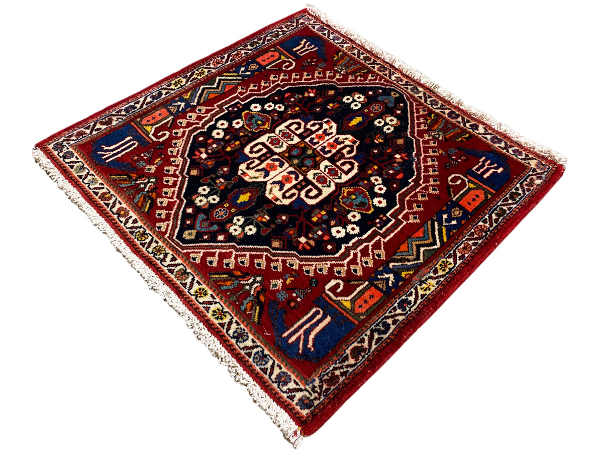 Tapis à bordure rouge et centre bleu foncé, ornement en forme d’étoile, franges