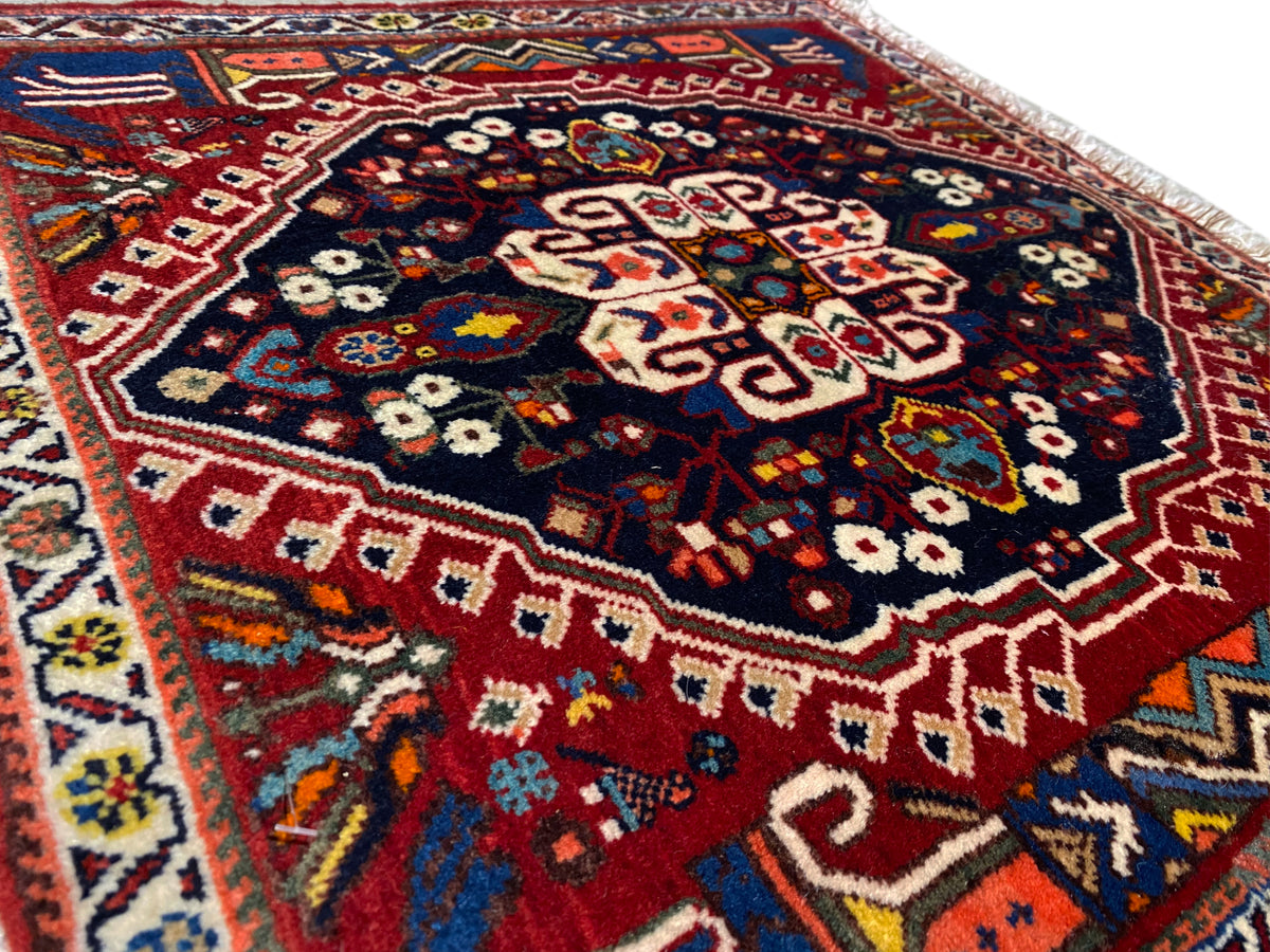 Gros plan du tapis avec un motif géométrique multicolore sur fond bleu foncé