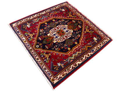 Tapis Poshti (67×67 cm) en diagonale : fond rouge, centre sombre avec des motifs blancs
