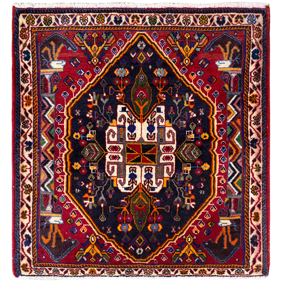 Tapis carré à fond bleu foncé, bordure rouge et motifs ornementaux, 70x67 cm