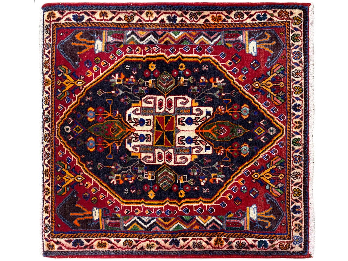 Tapis carré à fond bleu foncé, bordure rouge et ornement centré, 70x67 cm