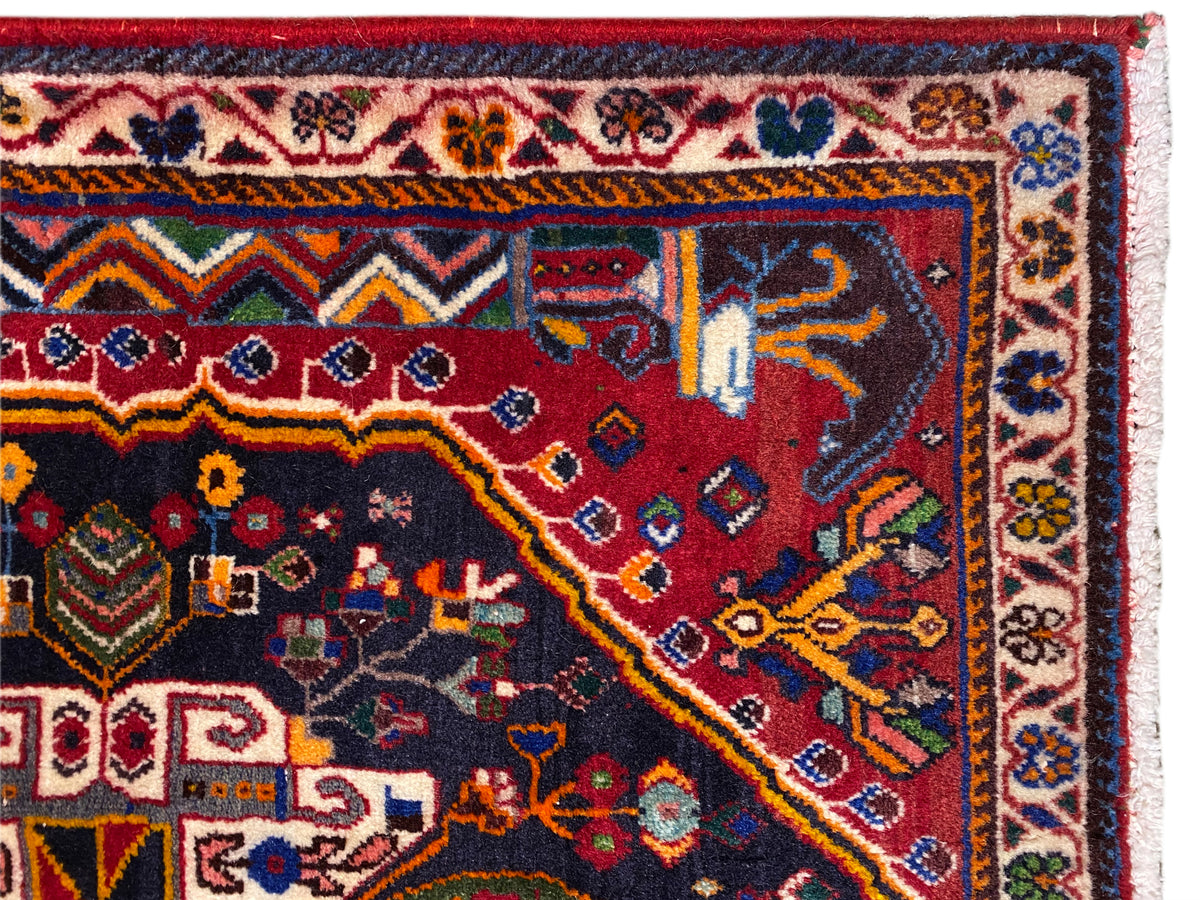 Bord de tapis avec bordure décorative, motif rouge et bleu et franges blanches, vue détaillée
