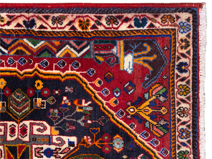 Bord de tapis avec bordure décorative, motif rouge et bleu et franges blanches, vue détaillée