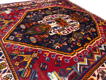 Gros plan de la surface du tapis avec un motif géométrique bleu, rouge et doré