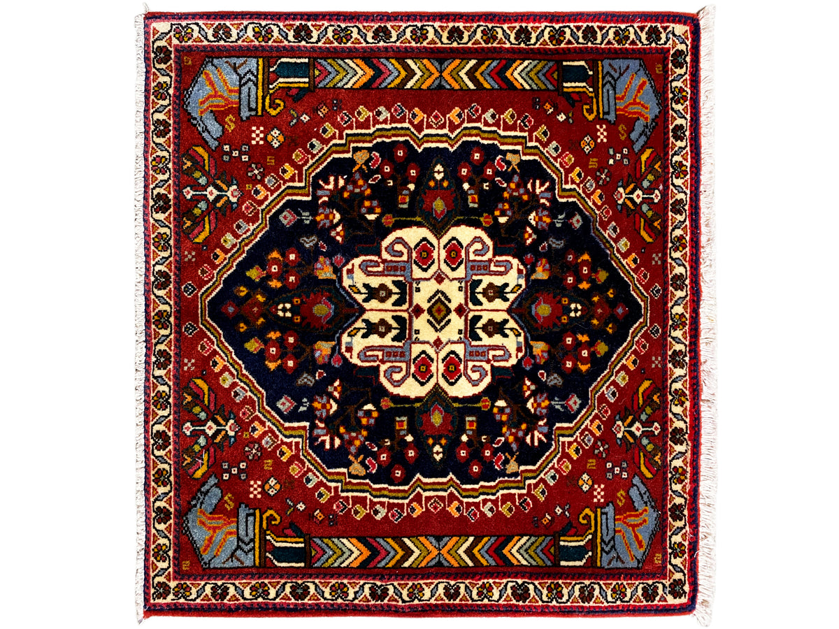 Tapis Poshti 65x61 cm avec bordure rouge, motif central sombre et ornements colorés