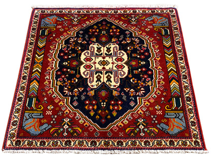 Tapis Poshti 65x61 cm, photo tournée : motif de bordure rouge avec médaillon sombre