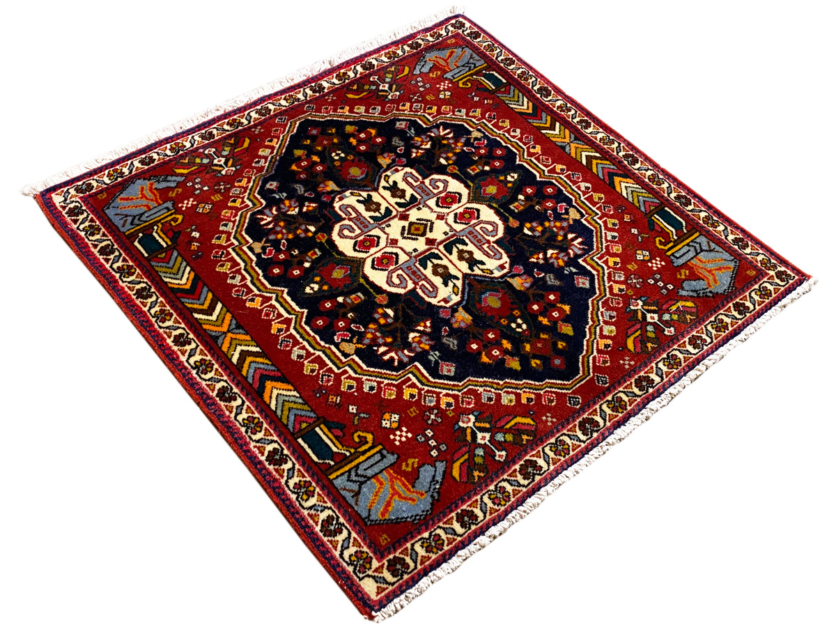 Tapis Poshti 65x61 cm, vue en diagonale : fond rouge avec centre bleu foncé