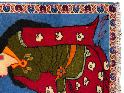 Tapis Poshti 65x63 cm, vue rapprochée : personnage vêtu de vert, champ rouge et bordure à franges