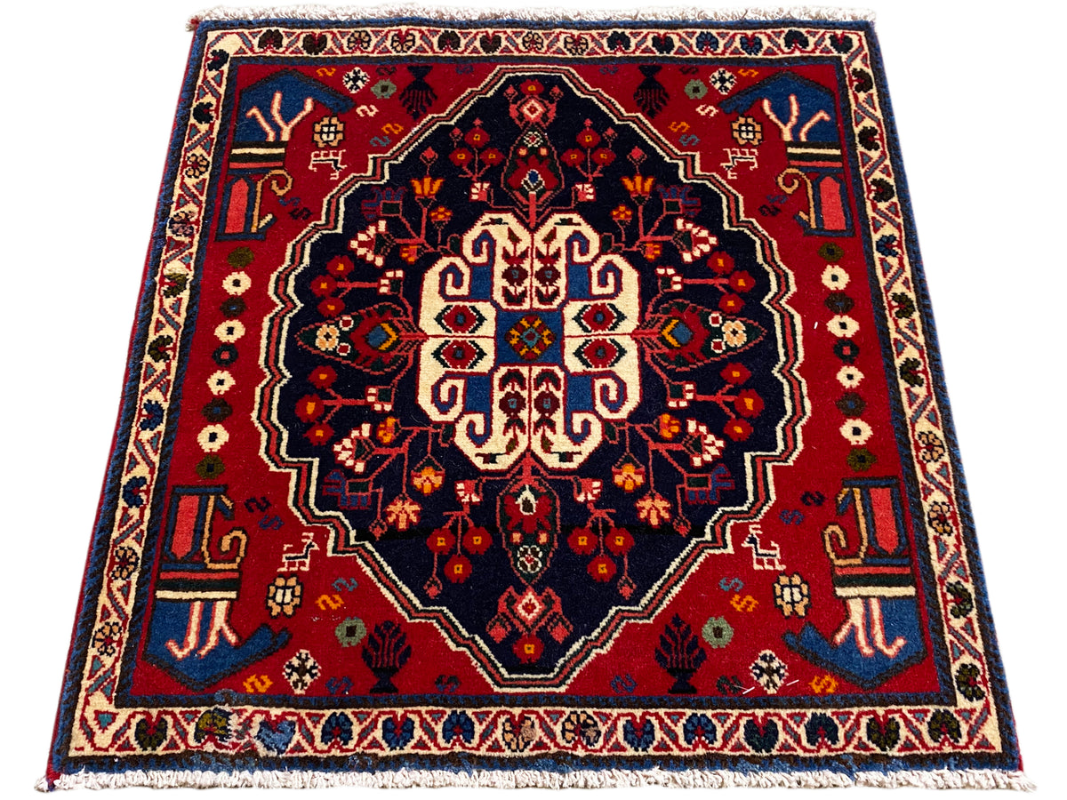 Tapis carré à bordure rouge et champ sombre, ornement central stylisé
