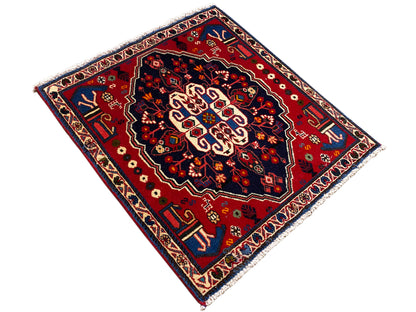 Tapis à motifs en losanges : champ à motifs rouges avec bordure bleue et ornements