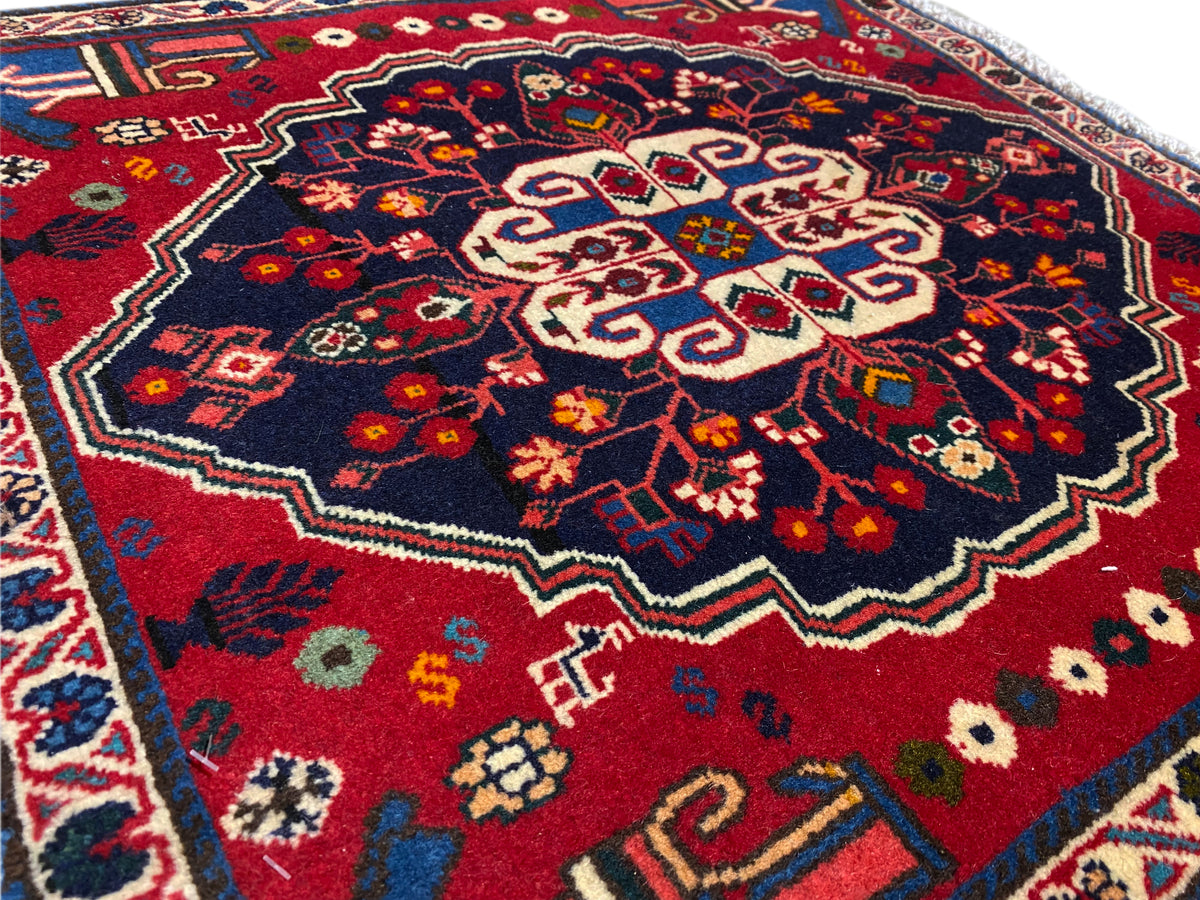 Extrait de tapis avec champ sombre et motif central géométrique beige